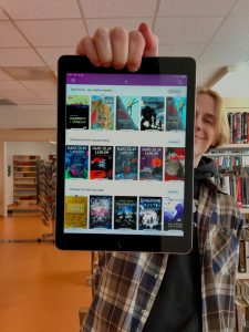 Bibliotekar holder nettbrett med Bookbites på skjermen